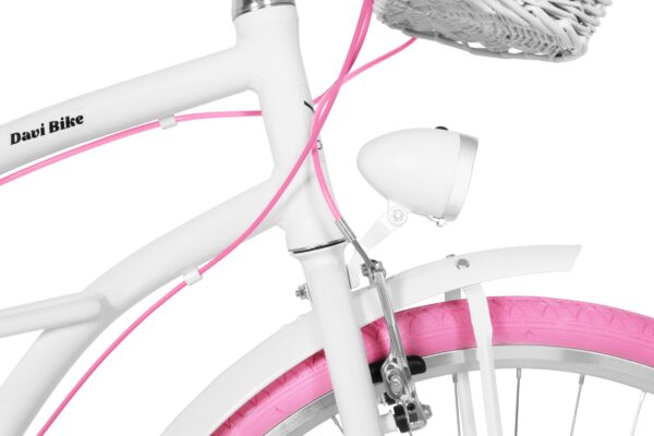 Biały rower z różowymi akcentami i koszykiem.