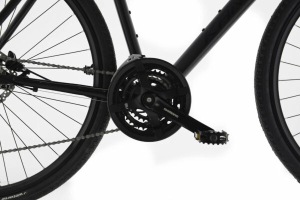 Cykelpedal och kedja på en svart cykel.