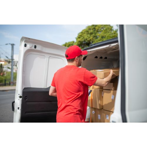 Kurir lastar paket i skåpbil utomhus.