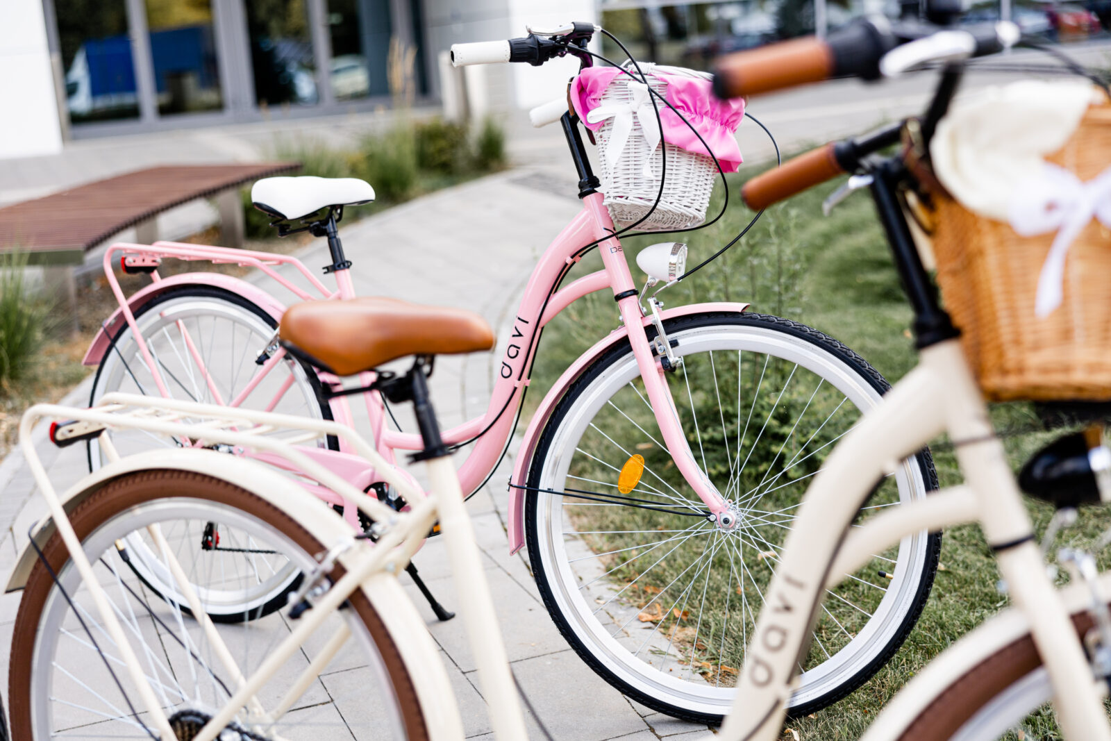 Dwa rowery, jeden różowy, drugi kremowy na chodniku.