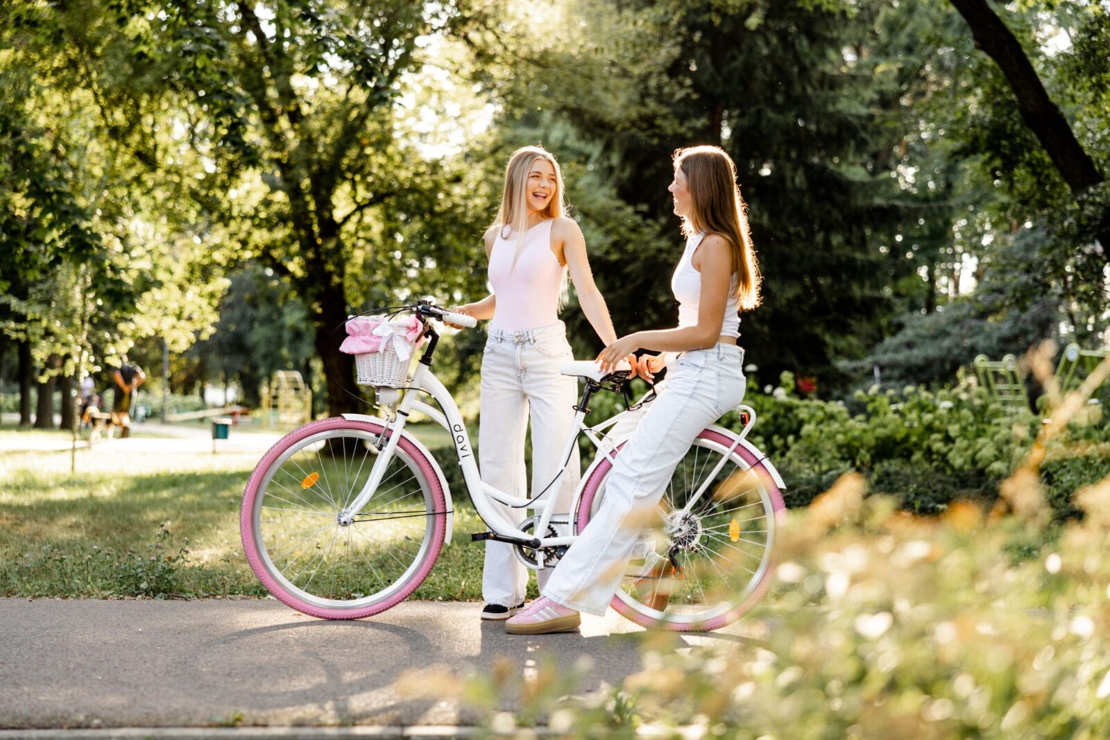 Dwie dziewczyny rozmawiają przy rowerze w parku