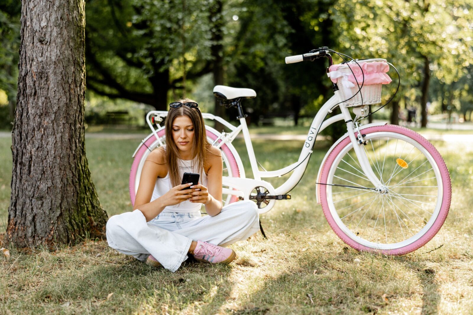 Kobieta siedzi przy rowerze w parku