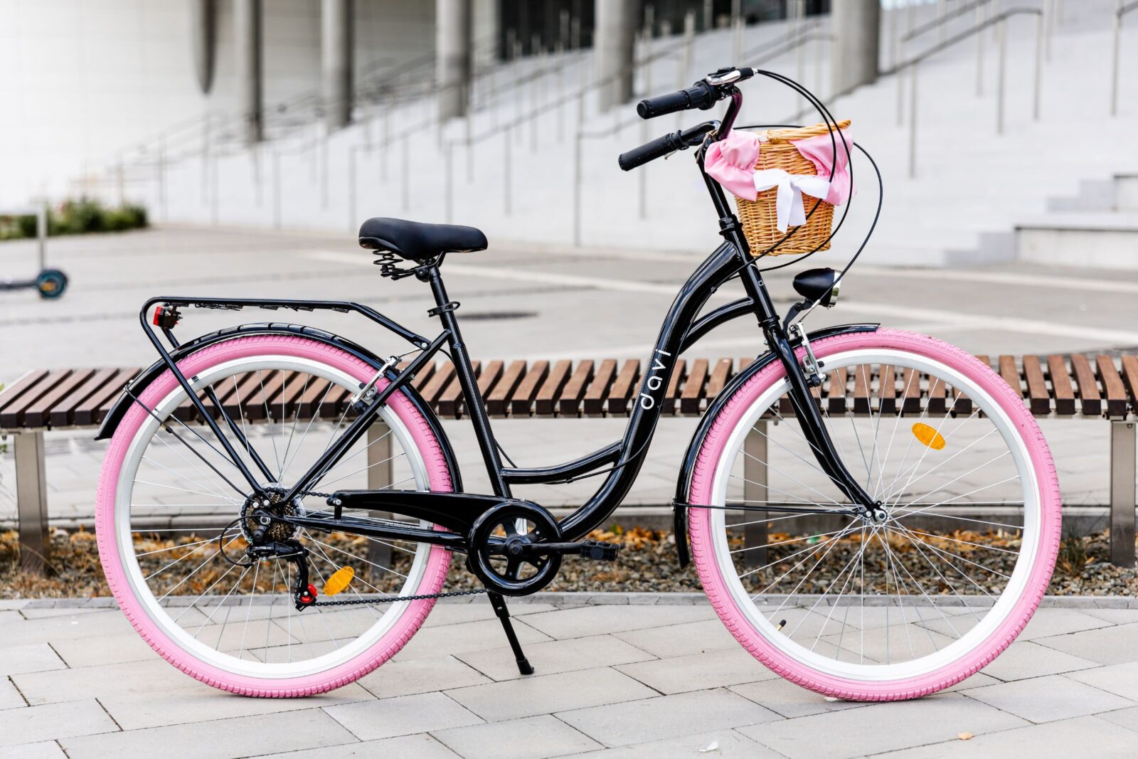 Czarny rower z różowymi oponami i koszem