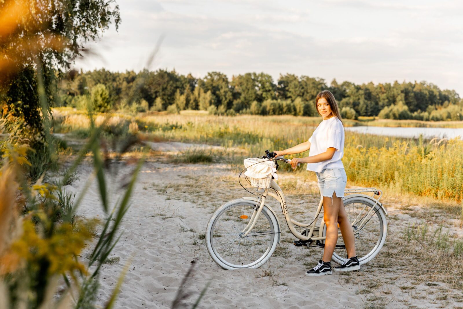 Kobieta stojąca obok roweru na plaży