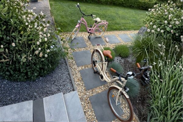 Dwa rowery na pięknym ogrodowym chodniku