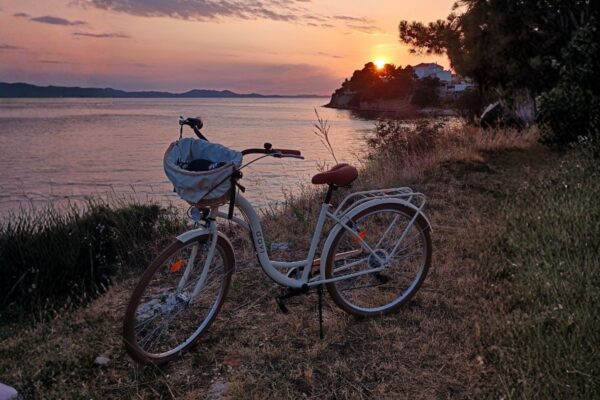 Rower nad brzegiem morza o zachodzie słońca.
