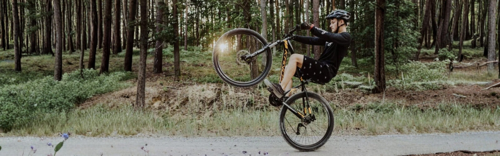 Mężczyzna jeździ na rowerze w lesie.