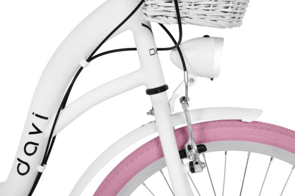 Biały rower z różowym pedałem i koszykiem